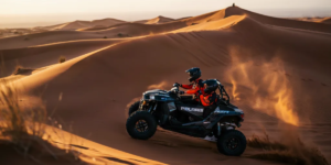 2 Hour Dune Buggy Climbing Red Sand Dunes - Lahbab Dubai Powerful Polaris RZR 1000 dune buggy climbing a steep red sand dune in Lahbab Desert Dubai during golden hour, with sand spraying from wheels during a thrilling 2 hour self-drive desert adventure