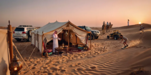 Complete desert safari experience in Dubai featuring traditional Bedouin camp with camel rides, sandboarding, dune buggies, and authentic Arabian hospitality at sunset