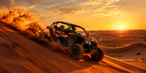 Powerful self-drive Can-Am Maverick X3 dune buggy conquering massive red sand dune at sunset in Lahbab Desert Dubai with sand spraying from wheels