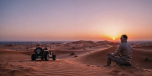 Dune buggy conquering steep red sand dune at sunset in Lahbab Desert Dubai with dramatic golden light and sand flying from wheels